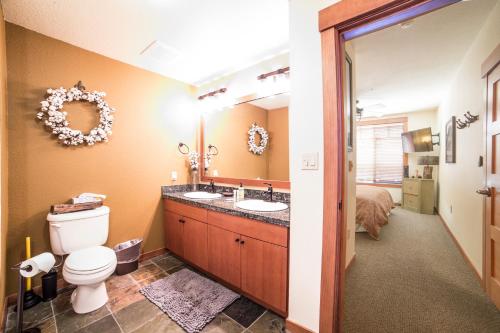 a bathroom with a toilet and a sink and a bed at White Mountain Lodge #2329 in Mammoth Lakes