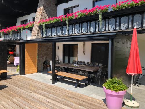a patio with a wooden table and a bench on a building at Landhaus Osttirol in Iselsberg