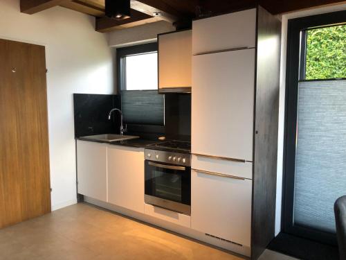 a kitchen with stainless steel appliances and a window at Landhaus Osttirol in Iselsberg