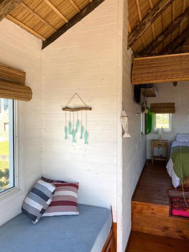 a small room with a bed and a window at Cabañas Punta Papaya in Punta Del Diablo