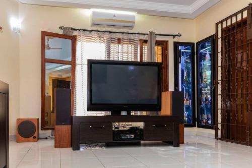 a living room with a flat screen tv on a entertainment center at VILLA PHOEBE Cité BOAD Lomé Baguida in Lomé