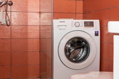 a washing machine in a bathroom next to a toilet at VILLA PHOEBE Cité BOAD Lomé Baguida in Lomé