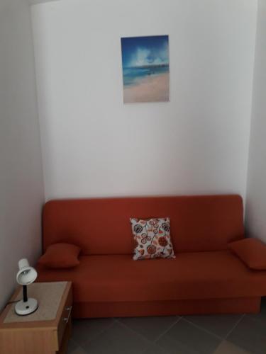 a living room with a red couch and a picture at Apartments Lidija in Pag
