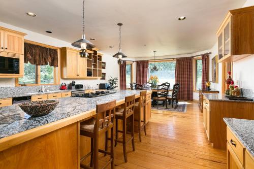 a kitchen with wooden cabinets and a large island with bar stools at Park City Homes by White Pines Solamere in Park City