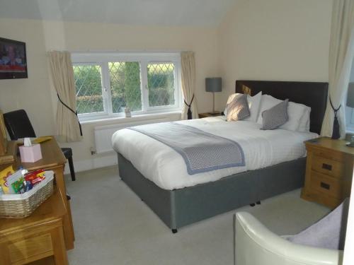 a bedroom with a large bed and a window at Trumbles Gatwick B&B in Charlwood