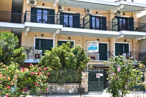 a building with balconies and flowers in front of it at Ionion Apartments & Studios in Nydri