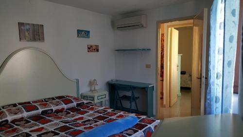 um quarto com uma cama, uma mesa e uma porta em Casetta nel centro di Sorgono em Sorgono