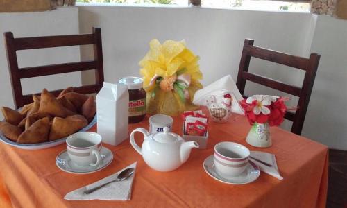 a table with cups and a bowl of bread at BeB Sardegna2 Anjumasa village in Watamu