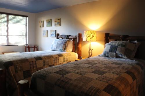 a bedroom with two beds and a lamp in it at Lone Fir Resort in Cougar