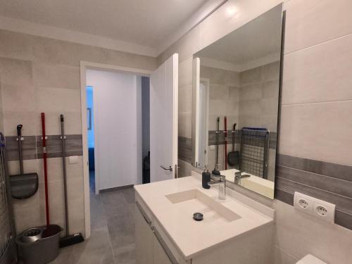 Apartamento nuevo en el centro con garaje في كاداكيس: حمام مع حوض ومرآة