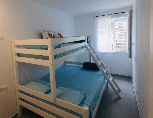 Etagenbett mit Leiter in einem Zimmer in der Unterkunft Apartamento nuevo en el centro con garaje in Cadaqués