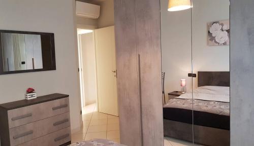 a bedroom with a bed and a dresser and a mirror at Residenza Adriatica 2 in Roseto degli Abruzzi