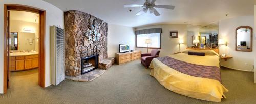 1 dormitorio con 1 cama grande y chimenea en GetAways at Snow Lake Lodge en Big Bear Lake