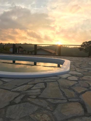 a skateboard ramp on a stone patio with the sunset at Chalés Alternativa Sítio in Conceição da Ibitipoca