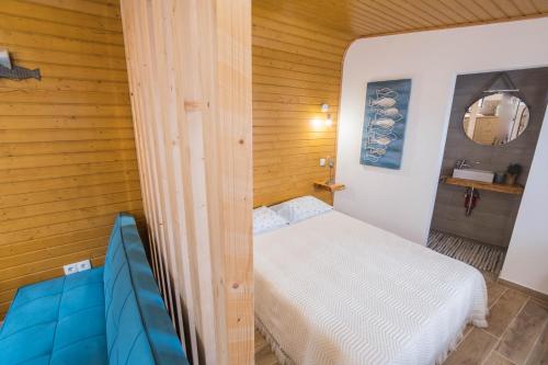 a small room with a bed and a blue couch at Casa do Mar - Nazaré in Nazaré