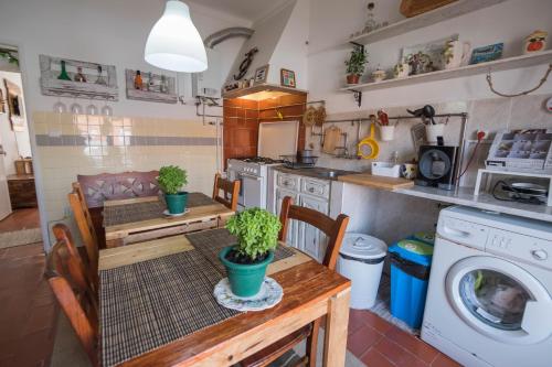 a kitchen with a table and a washing machine at Casa do Mar - Nazaré in Nazaré