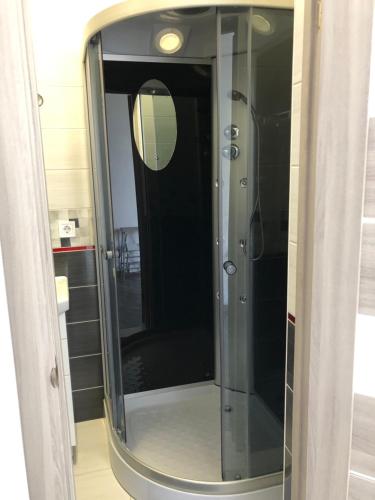 a glass shower in a bathroom with a mirror at Апартаменты Центр Трускавец in Truskavets