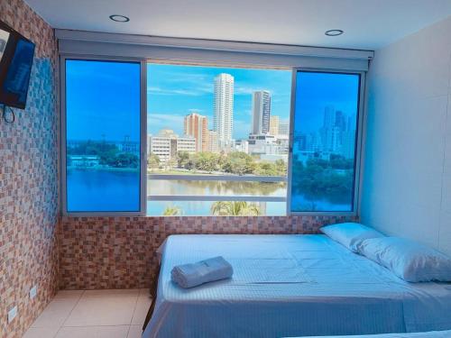 Cama en habitación con ventana grande en PyEnsa Cartagena en Cartagena de Indias