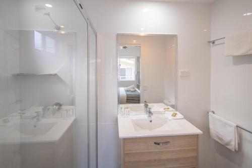 biała łazienka z umywalką i prysznicem w obiekcie Ingenia Holidays Lake Conjola w mieście Conjola