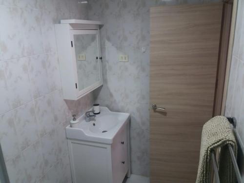 a bathroom with a white sink and a cabinet at Casa Dorotea in Playa del Cura