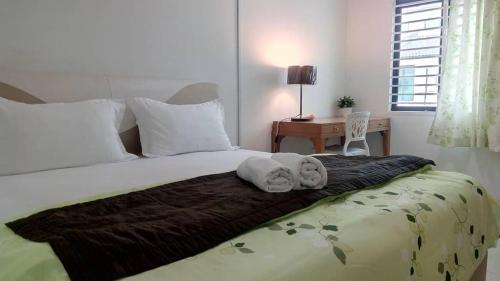 a bedroom with a bed with two towels on it at Tropicana Home Concept@Saujana KLIA, Sepang in Sepang