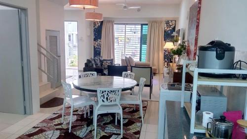 cocina y sala de estar con mesa y sillas en Tropicana Home Concept@Saujana KLIA, Sepang, en Sepang