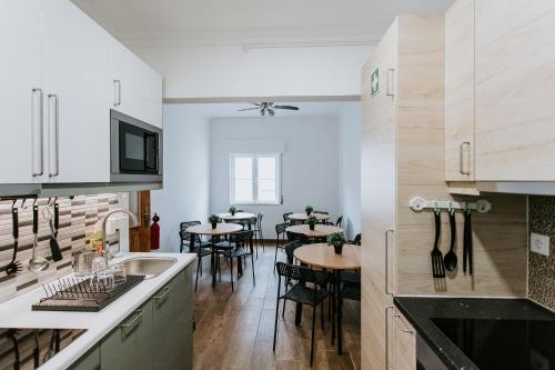 a kitchen with a sink and a table with chairs at DREAMS HOUSE in Faro