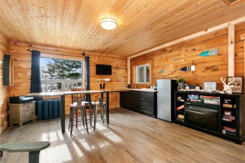 cocina con paredes de madera y encimera con taburetes en The Trace at Oak Lake (19+) en Havelock