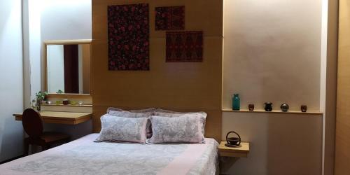 1 dormitorio con 1 cama con 2 almohadas y espejo en The Heritage Residence, en Seri Kembangan