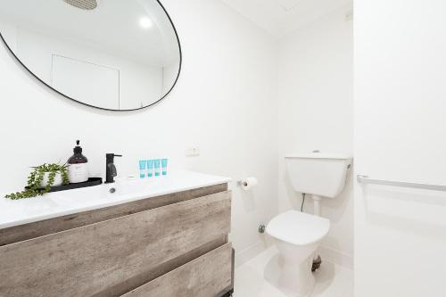 a bathroom with a sink and a toilet and a mirror at ULTIMATE BONDI LIVING in Sydney