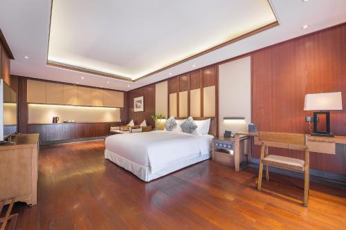a bedroom with a bed and a desk and a television at Floral Hotel ·Hefu Hotel (Hangzhou West Lake) in Hangzhou
