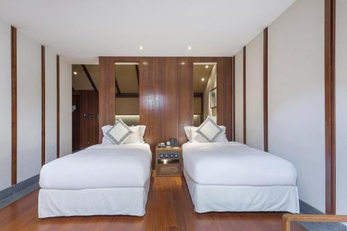 a bedroom with two beds and a mirror at Floral Hotel ·Hefu Hotel (Hangzhou West Lake) in Hangzhou