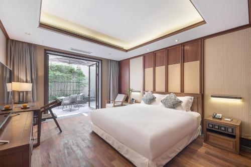 a bedroom with a large white bed and a desk at Floral Hotel ·Hefu Hotel (Hangzhou West Lake) in Hangzhou