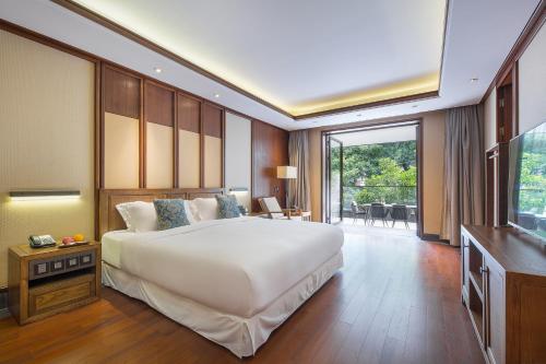 a bedroom with a large white bed and a balcony at Floral Hotel ·Hefu Hotel (Hangzhou West Lake) in Hangzhou