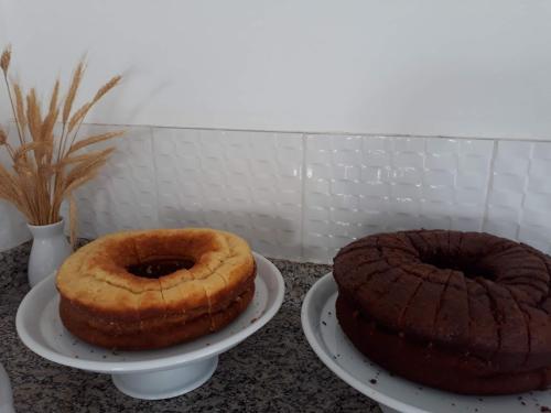 two cakes are sitting on plates on a counter at Hotel Plaza Campo Grande in Salvador