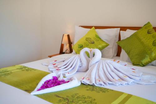 two swans made out of towels on a bed at Uluwatu Kayana Bungalows by Bukit Vista in Uluwatu