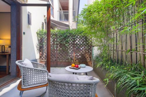 a patio with two chairs and a table with a candle at Floral Hotel ·Hefu Hotel (Hangzhou West Lake) in Hangzhou