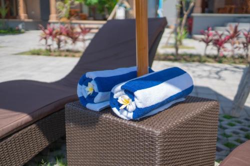 two towels sitting on top of a wicker chair at Uluwatu Kayana Bungalows by Bukit Vista in Uluwatu