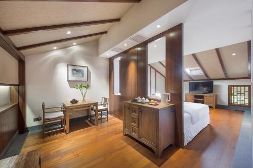 a bedroom with a bed and a desk and a table at Floral Hotel ·Hefu Hotel (Hangzhou West Lake) in Hangzhou