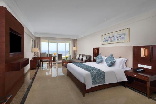 a hotel room with a bed and a living room at Wyndham Garden Wenchang Nanguo in Wenchang