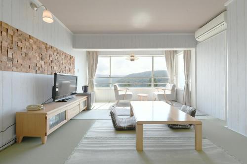 a living room with a tv and a table at Hotel Ra Kuun in Hakone