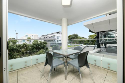 a table and chairs on a balcony with a view at The Anchorage Apartments in Mount Maunganui
