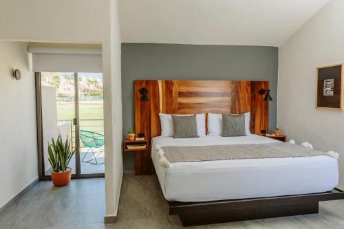 1 dormitorio con 1 cama grande y balcón en SIX TWO FOUR Urban Beach Hotel en San José del Cabo