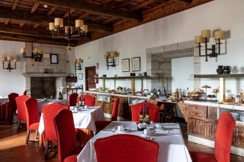 restauracja ze stołami i czerwonymi krzesłami oraz bar w obiekcie Parador de Monforte de Lemos w mieście Monforte de Lemos