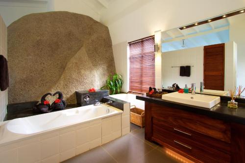 a bathroom with a bath tub and a sink at Hillcrest Villas in Glacis
