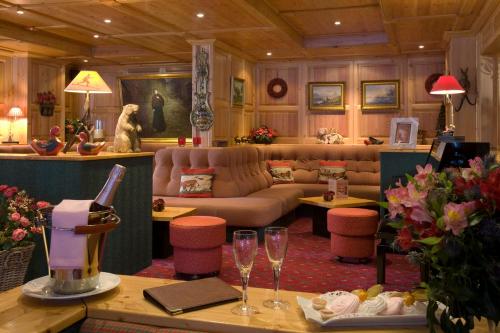 uma sala de estar com um sofá e uma mesa com copos de vinho em Le Souleil'Or em Les Deux Alpes