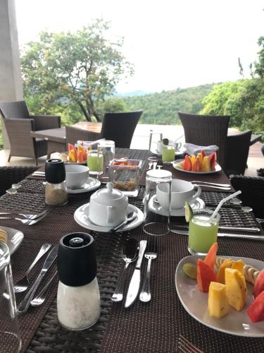 a table with plates of food and fruit on it at Treehouse Chalets - Luxury getaway within a short distance of Ella in Belihul Oya