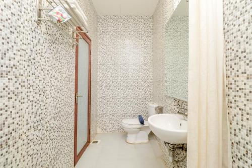 a bathroom with a toilet and a sink at Blitz Hotel Batam Tanjung Uncang in Sekupang