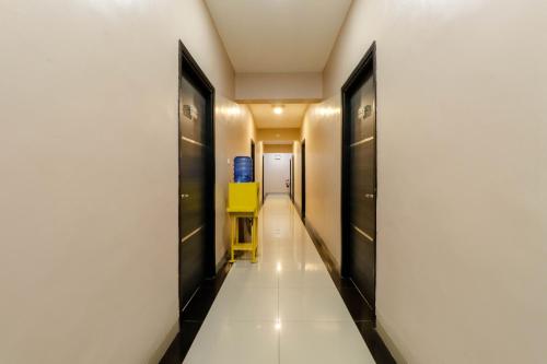 a hallway with a yellow chair in a building at Blitz Hotel Batam Near Sultan Mahmud Ri'ayat Shah in Sekupang