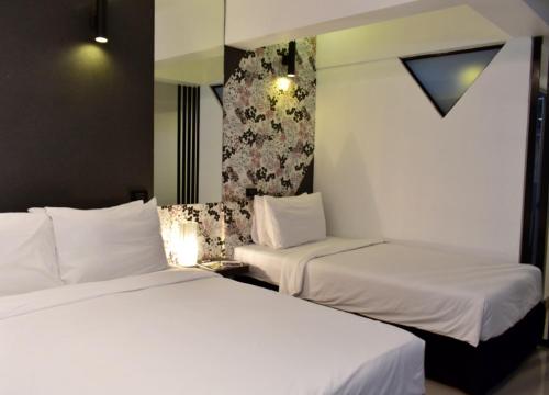 two beds sitting next to each other in a room at Loyy Hotel in Chiang Mai